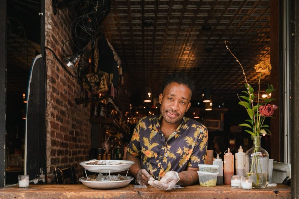 Restaurant owner preparing fresh oysters at the counter of a small restaurant